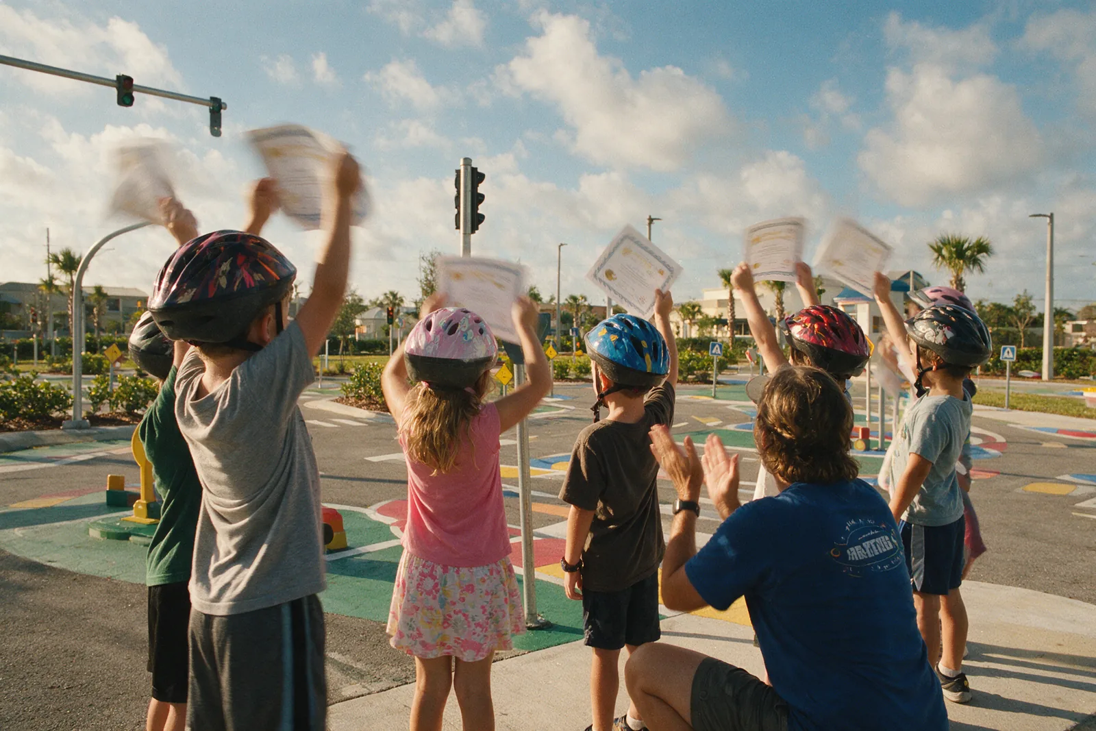 Children in helmets holding certificates